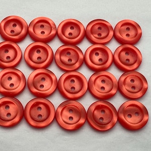 Peut inclure: Un ensemble de 18 boutons en plastique rouge à deux trous.