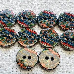 May include: A collection of ten round wooden buttons with a colorful, geometric design. The buttons feature a pattern of blue, red, orange, and green shapes. Each button has two holes for sewing.