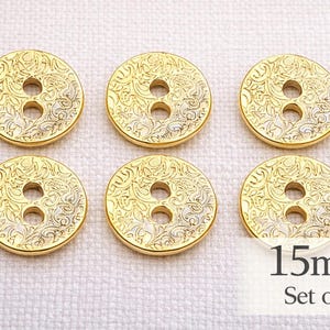 May include: Six gold-coloured buttons with an ornate floral design. Each button has two holes and is 1.5cm in diameter. The set includes six buttons.