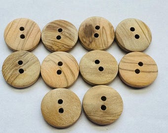 May include: Ten round wooden buttons with two holes each. The buttons have a light brown color with darker wood grain patterns. These buttons are suitable for sewing projects and crafts.