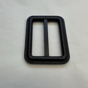 May include: Black plastic buckle with a stitched edge.