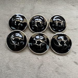 Peut inclure: Six boutons noirs et blancs avec un bord argenté.