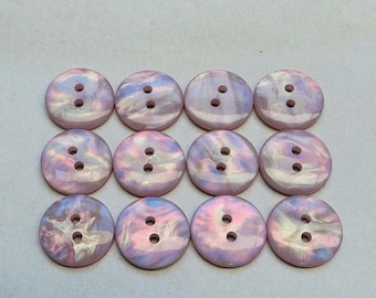 May include: Twelve iridescent, round buttons, each with two holes. The buttons display a swirling pattern of pink, purple, and blue. These decorative buttons are suitable for sewing and craft projects.