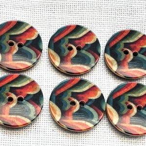 May include: A set of six round, two-hole buttons featuring a repeating abstract pattern of wavy, layered bands in shades of orange, teal, dark green, and cream. Each button has a smooth, flat surface and a consistent circular shape.
