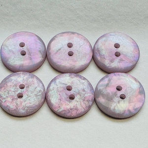 May include: Six two-hole round buttons with a pink and white marbled design.