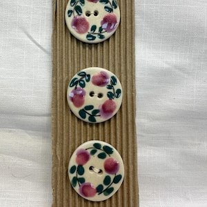 Op de afbeelding: Een set van drie keramische mokken met een gespikkelde, matte afwerking. De mokken zijn in crème, lichtgrijs en donkergrijs. Elke mok heeft een eenvoudig, modern ontwerp en een afgeronde handgreep.