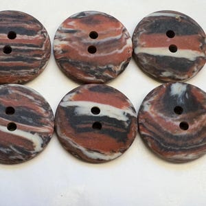 May include: Six two-hole round buttons with a marbled pattern in shades of brown, red, and white.