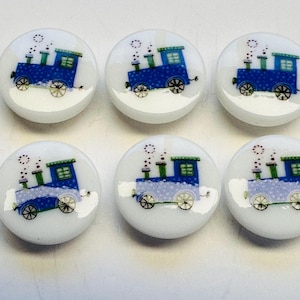 Puede incluir: Seis pomos de armario redondos de cerámica blanca con un diseño de tren azul. Cada pomo presenta un tren azul con detalles verdes, ruedas negras y un efecto de humo punteado. Ideal para la habitación de un niño.