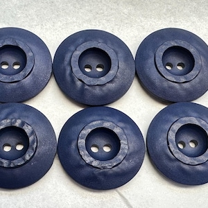 Botones azul marino de 28 mm, juego de seis, con diseño de centro en relieve texturizado.