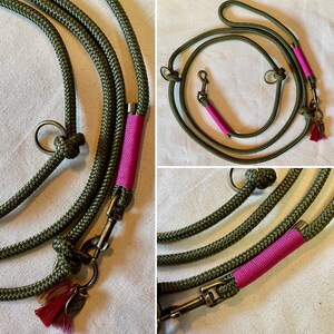 May include: A green rope dog leash with two clips and a pink accent. The leash has a tassel on one end.