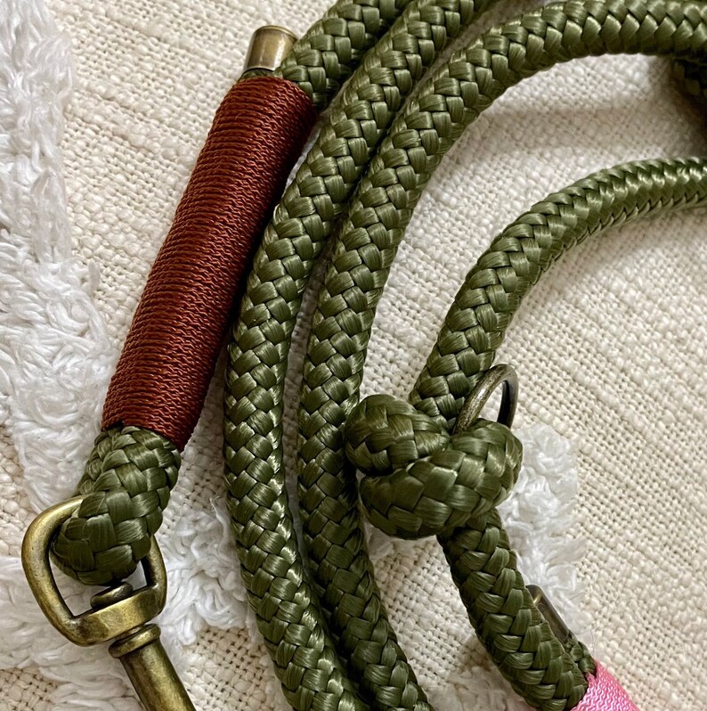 May include: A green and brown rope dog leash with a brass clasp and a knot at the end.