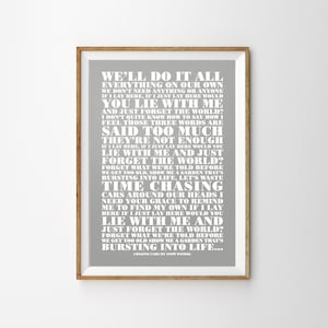 Puede incluir: Un póster imprimible gris y blanco con la letra de la canción "Chasing Cars" de Snow Patrol. La letra está impresa en una fuente grande y en negrita y está dispuesta en una columna vertical. El póster está enmarcado en un marco marrón claro.