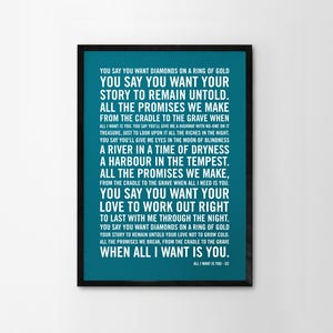 May include: A framed teal print with white song lyrics. The black frame surrounds the teal background, displaying the song's lyrics in a clean, sans-serif font. The text includes the song title and artist.