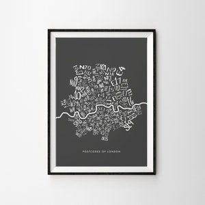 May include: A framed print showing a map of London postcodes in white on a dark grey background. The text "POSTCODES OF LONDON" is at the bottom. The map includes the Thames and various postcode districts.