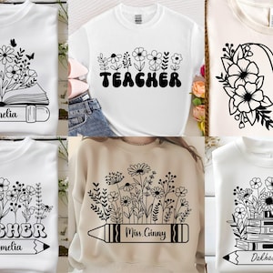 Peut inclure: Collection de t-shirts blancs et un sweat-shirt beige avec des motifs floraux et des graphiques sur le th&egrave;me des enseignants. Les motifs comprennent des livres ouverts, des crayons et le mot "Teacher". Certains ont des noms comme "Ms. Amelia" et "Miss Ginny".