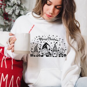 May include: White hooded sweatshirt with a black and white graphic of gnomes and the text "Merry Christmas".