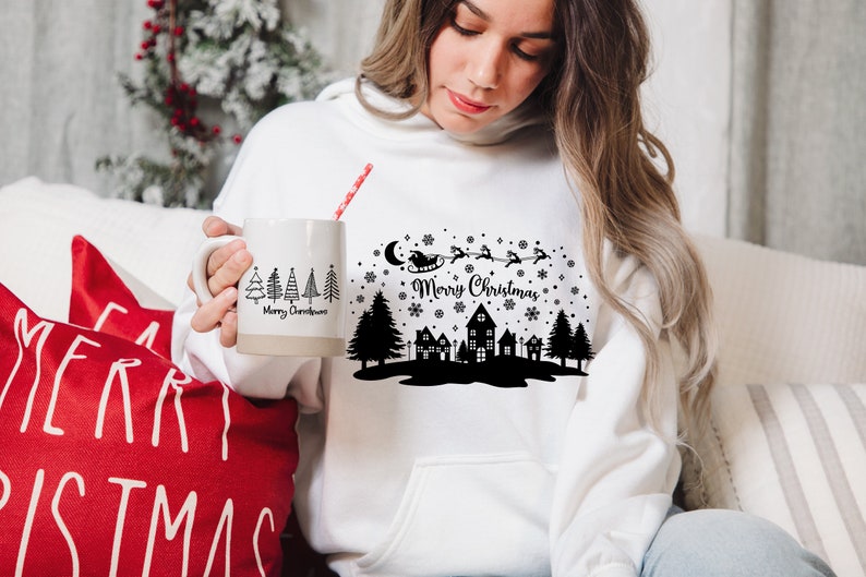 May include: White hoodie with a black and white Christmas design featuring a silhouette of a town, trees, Santa Claus in a sleigh, and the text "Merry Christmas".