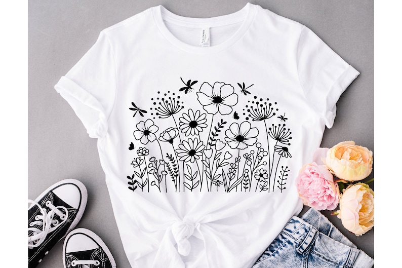 K&ouml;nnte beinhalten: Wei&szlig;es T-Shirt mit einer schwarzen Linienzeichnung eines Blumenstrau&szlig;es und Libellen.