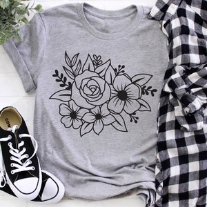 May include: A gray t-shirt with a black floral design featuring a rose and other flowers.