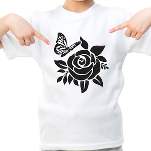 Pode incluir: Uma camiseta branca com uma silhueta preta de uma rosa e uma borboleta.