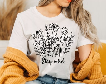 May include: White t-shirt with a black line drawing of flowers and the text "Stay wild".