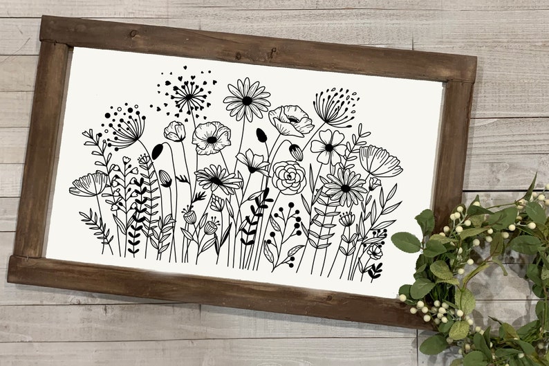 K&ouml;nnte beinhalten: Schwarzwei&szlig;-Linienkunst-Druck eines Blumenstrau&szlig;es mit verschiedenen Blumen und Bl&auml;ttern. Der Druck ist in einem rustikalen braunen Holzrahmen gerahmt.