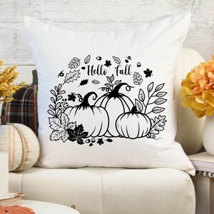 May include: White throw pillow with black and white graphic design of pumpkins and leaves. The text "Hello Fall" is printed on the pillow.