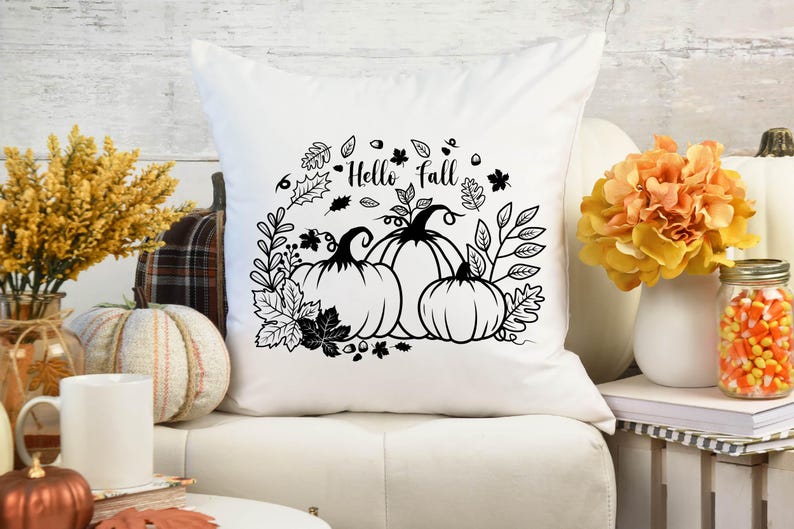 May include: White throw pillow with black and white graphic design of pumpkins and leaves. The text "Hello Fall" is printed on the pillow.