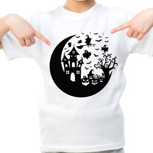 May include: White t-shirt with a black graphic of a crescent moon, a haunted house, a witch flying on a broomstick, bats, ghosts, and pumpkins.