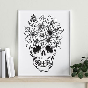 May include: Black and white line art print of a skull with a floral crown. The skull has a detailed design with a flower crown on top. The print is on a white background.