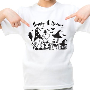 May include: White t-shirt with a black graphic of a gnome wearing a witch hat and holding a broom, with a ghost and three pumpkins. The text "Happy Halloween" is above the graphic.