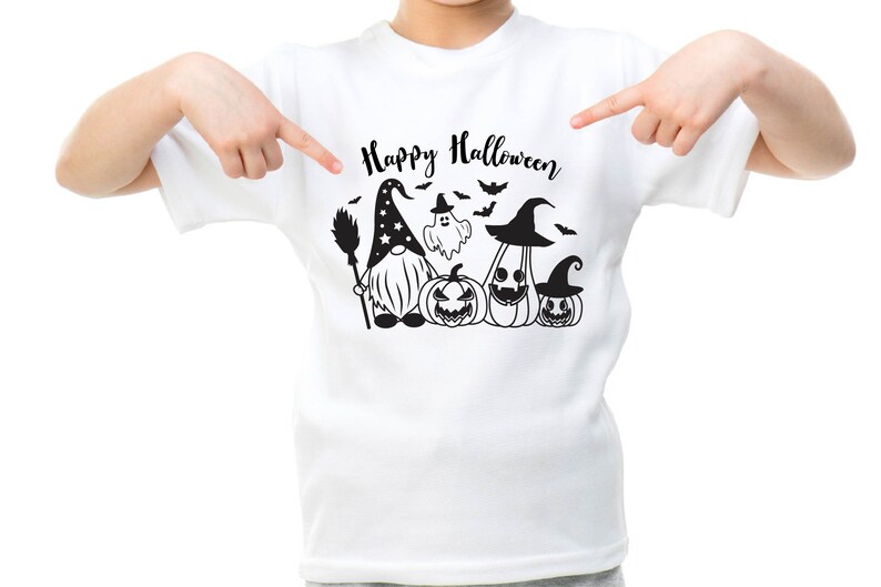 May include: White t-shirt with a black graphic of a gnome wearing a witch hat and holding a broom, with a ghost and three pumpkins. The text "Happy Halloween" is above the graphic.