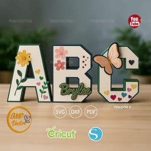 May include: Three-dimensional letters A, B, and C, each with a white face and green edges. Letter A has a yellow flower and green leaves. Letter B has pink flowers and the name "Brylee". Letter C has a butterfly and hearts. The letters are decorative.