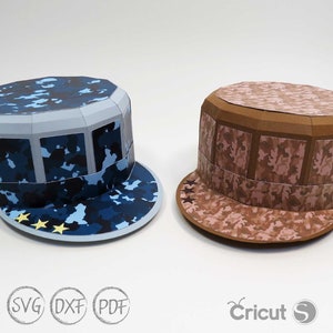May include: Two papercraft hats in camouflage patterns. One hat is blue and the other is brown. Both hats have a brim and a flat top.