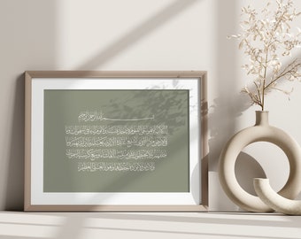 Op de afbeelding: Een ingelijst afdruk met een groene achtergrond en witte Arabische kalligrafie. De tekst luidt "المال الأمر الحي القيوم والجار سكنه و يوم اليها في السموات وما في ارض من الذي يشفع عنده الالمانية يعلمها من الديرونا حالهم والحطور هو عالية الالما شاء وسيع كرسي المسموك والار مورد بوده حفظه وهو العلى العظيم".