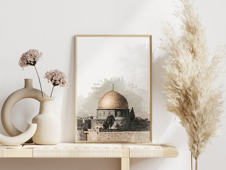 May include: A watercolor print of the Dome of the Rock in Jerusalem, a golden dome with intricate details, set against a light gray background with watercolor splatter effects.