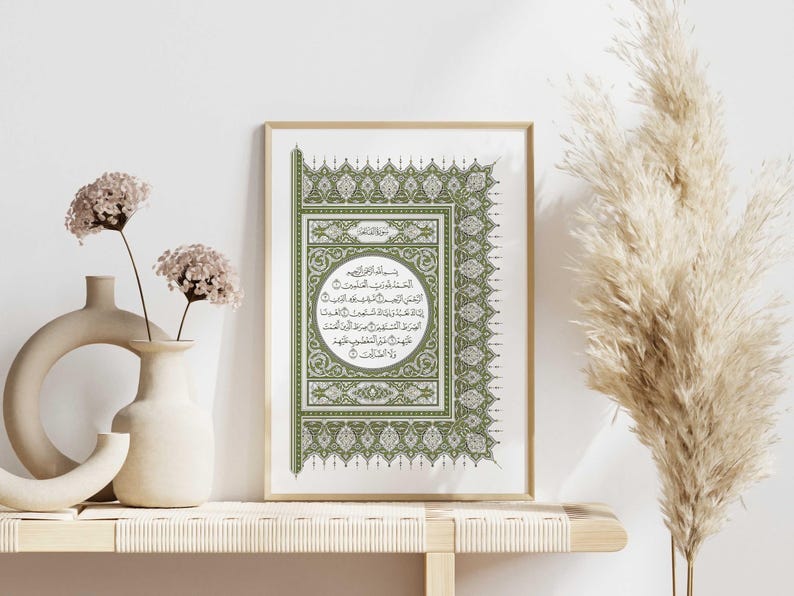 May include: A framed print featuring a green and white Islamic calligraphy design. The design incorporates intricate floral patterns and Arabic script.
