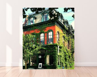 May include: A red brick building with green trim and ivy growing up the sides. The building has large windows and a door with a sign that says "Open".