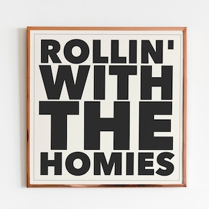 May include: A framed print with the text "ROLLIN' WITH THE HOMIES" in black bold letters on a white background.