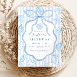 May include: A light blue and white striped birthday invitation with watercolor seashell illustrations. The invitation includes the text "Jordana's Birthday" and event details. The design features a bow and scalloped border.