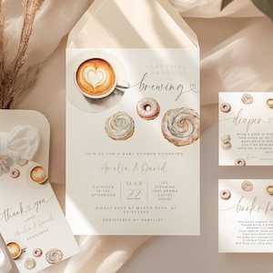 May include: A baby shower invitation suite with a watercolor illustration of coffee and donuts. The invitation reads "Something sweet is brewing" and includes the date, time, and location of the event. There are also cards for a diaper raffle and a "Books for Baby" gift request.