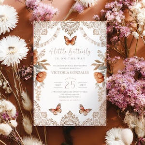 May include: A baby shower invitation with a butterfly theme. The invitation features floral and butterfly illustrations in shades of brown and orange. The text reads "A little butterfly is on the way". The date is October 25th.