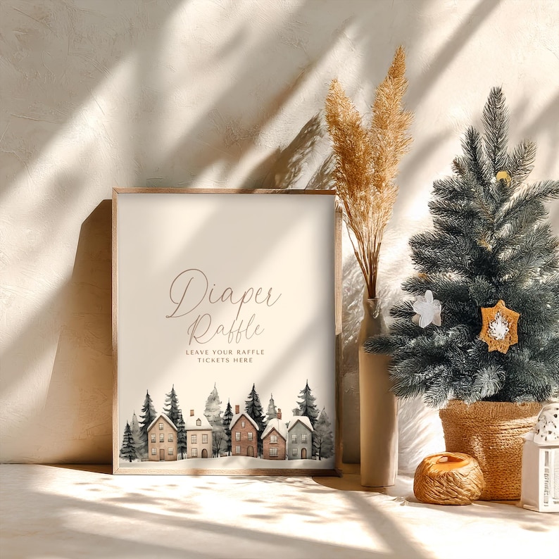 May include: A framed sign with the words "Diaper Raffle" in elegant script. Below, it reads "Leave Your Raffle Tickets Here." The bottom features a watercolor illustration of houses and trees. A small Christmas tree and vase are in the background.