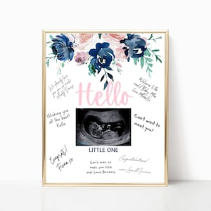 Puede incluir: Un cartel blanco enmarcado con un diseño floral en tonos azules y rosas. El cartel dice "Hello" en letras rosas y presenta una imagen de ultrasonido. El cartel también incluye el texto "Welcome to the world Baby Mou Love Mielle", "Wishing you all the best! Kellie", "Can't wait to meet you!", "Congrats! Fiona xo", "LITTLE ONE", "Can't wait to meet you little one! Love Brittany", y "Congratulations xoxo Love Marina".