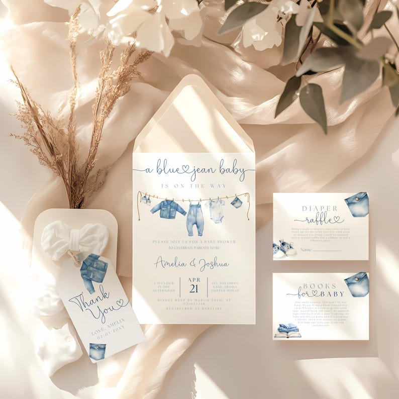 May include: Baby shower invitation set with a blue jean theme. The invitation features a watercolor illustration of baby clothes hanging on a clothesline. Includes a thank you tag, diaper raffle card, and books for baby card.