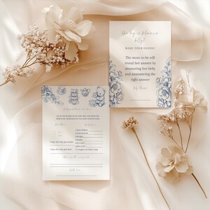 May include: A blue and white baby shower game card with a floral design. The card asks guests to guess the baby's birth details, such as the time of birth, weight, and length. The card also includes a section for guests to write their guesses for the baby's gender and hair color.