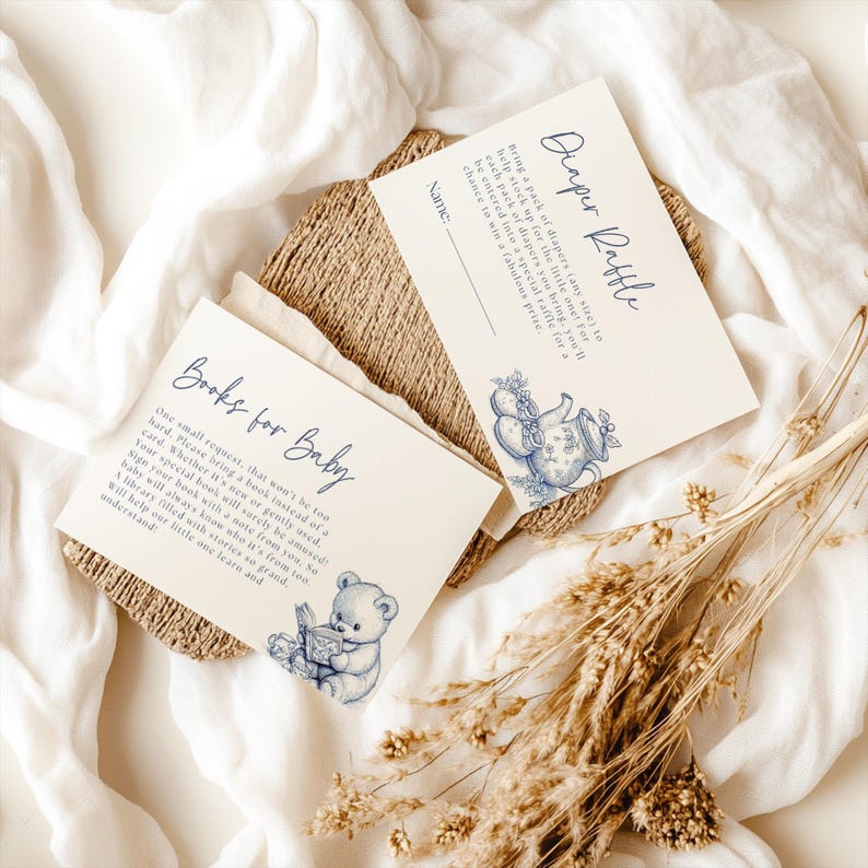 Peut inclure: Deux cartes avec des illustrations bleues et blanches. La carte du haut dit "Diaper Raffle" et repr&eacute;sente une th&eacute;i&egrave;re et des fleurs. La carte du bas dit "Books for Baby" et repr&eacute;sente un ours en peluche en train de lire un livre. Les deux cartes ont un fond blanc.