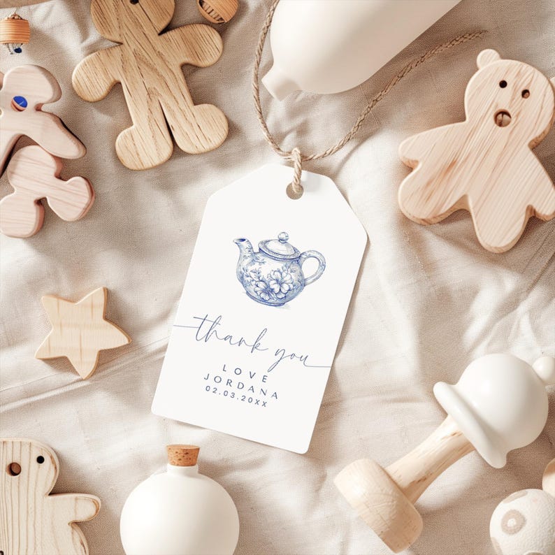 Peut inclure: Une &eacute;tiquette de remerciement blanche avec une illustration de th&eacute;i&egrave;re bleue et blanche. L'&eacute;tiquette dit "merci" en cursive et "love Jordana 02.03.20XX".