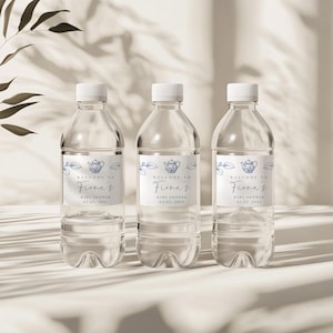May include: Three clear plastic water bottles with blue and white labels that say "Welcome to Fiona's Baby Shower 02.02.20XX".