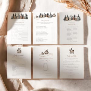 May include: Six cream-colored baby shower game cards with watercolor illustrations of houses and trees. The cards include games like "Baby Scramble" and "Guess how many jellies are in the jar?"
